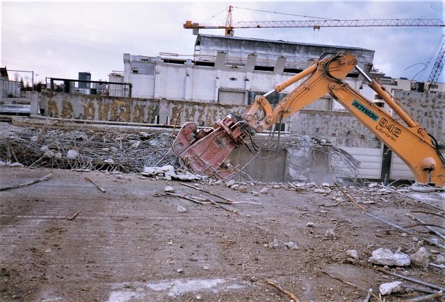 Abbruchzange am Baggerausleger im Einsatz auf einer Gebäude-Abbruchbaustelle